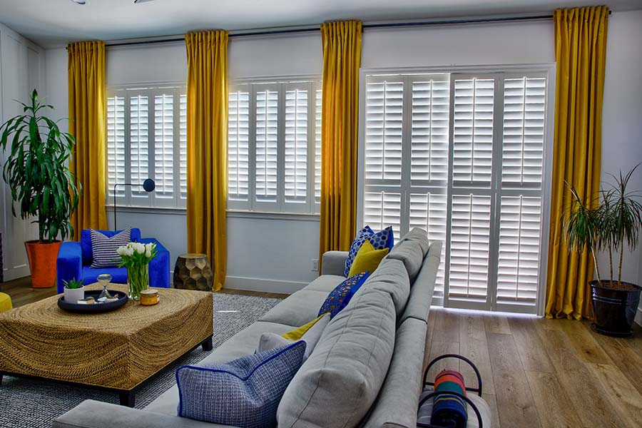 White Polywood shutters on a sliding glass door in a family room